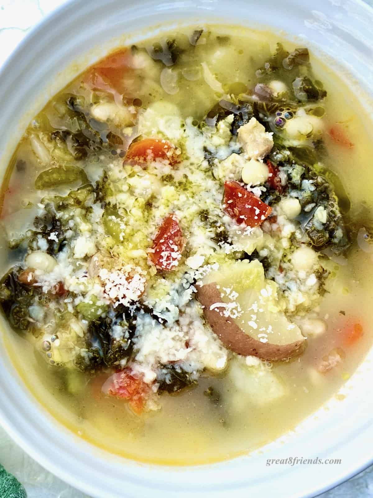 Overhead shot of vegetable soup in a bowl sprinkled with parmesan cheese.