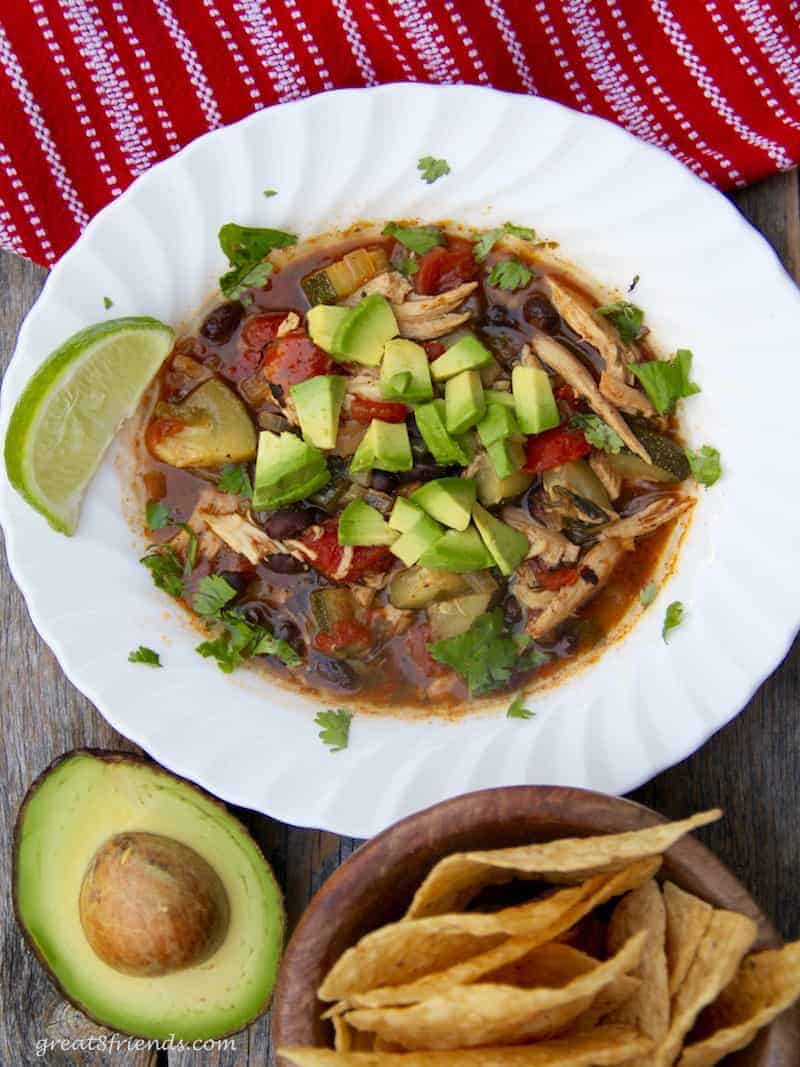 Overhead shot of chicken tortilla soup with avocado and tortilla chips.