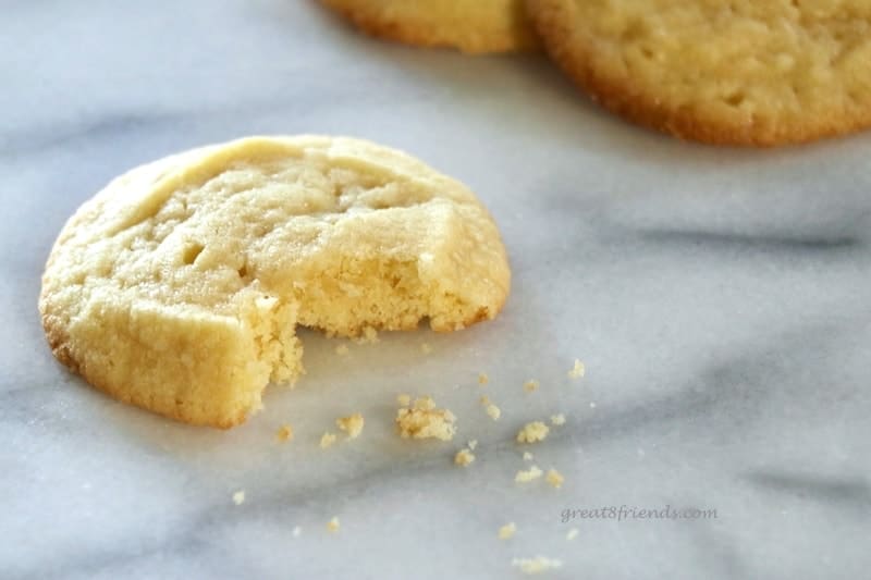 One butter cookie with a bite taken out of it.