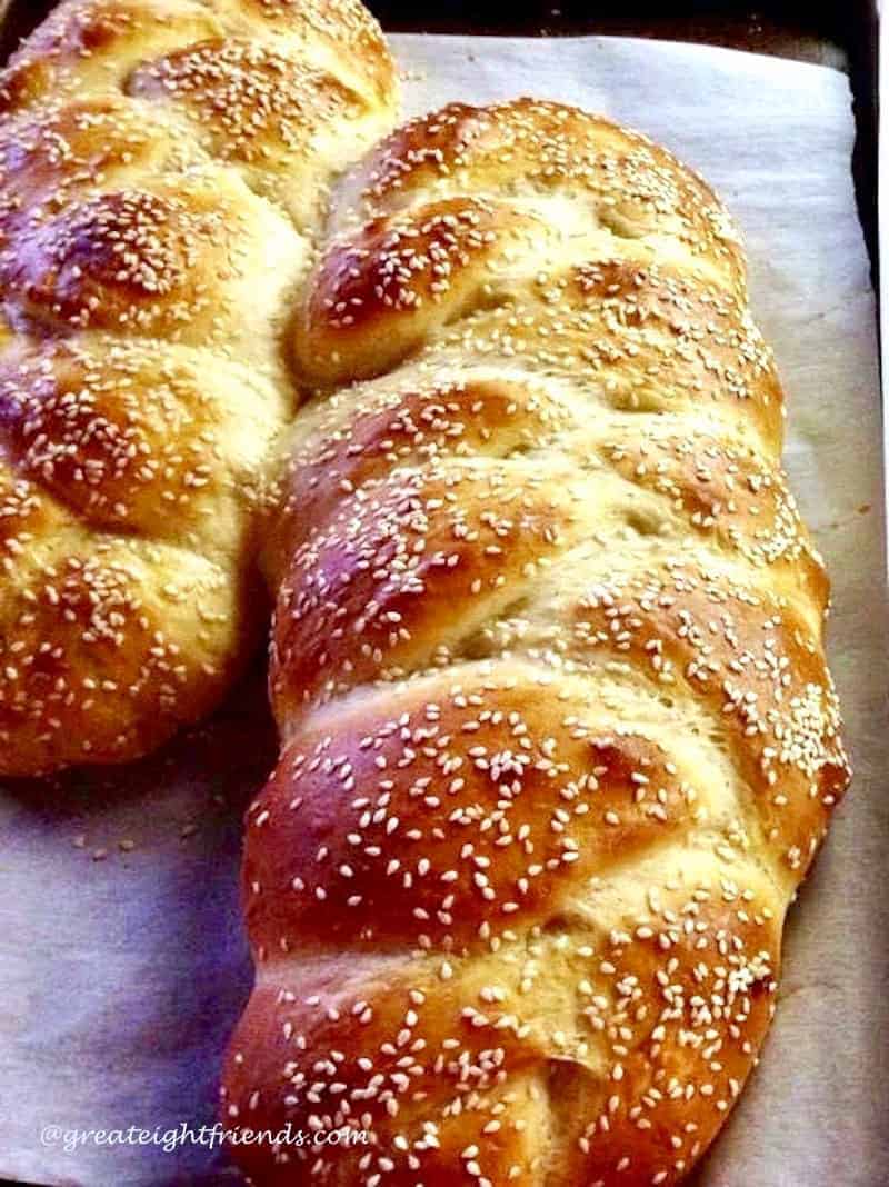 two loaves of Challah bread topped with sesame seeds.