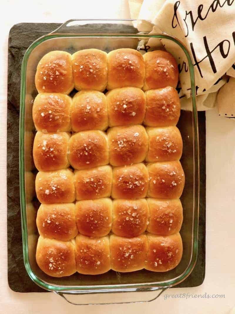 Overhead shot of a 9x13 glass dish with dinner rolls sprinkled with salt.