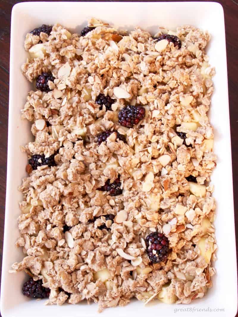 Apples and Blackberries in a baking pan with the streusel ready for baking.