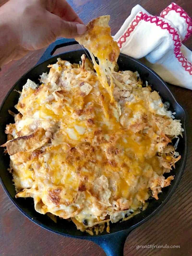 Cheesy nachos in a cast iron pan.