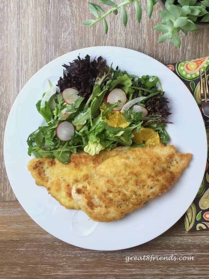 Chicken cutlets on a plate with a small side salad.