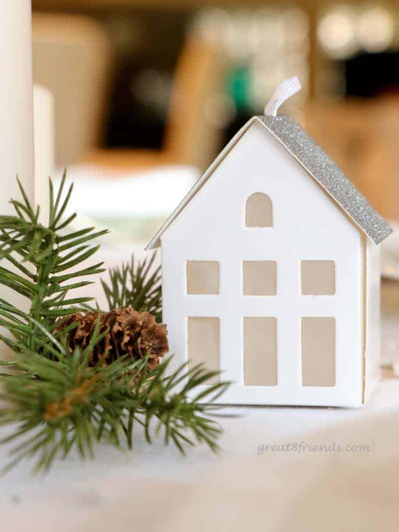 A  close up of small white paper house used in centerpiece