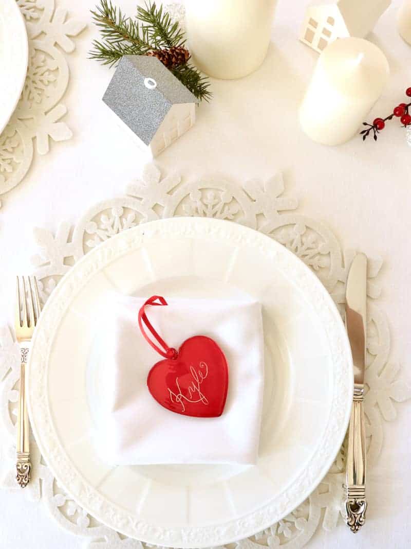 Overhead shot of one place setting with white plate and red glass place card.