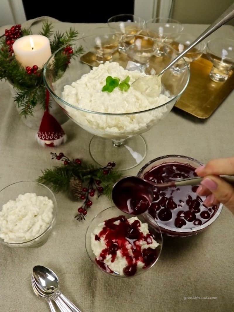 A large bowl of rice pudding with cherry sauce on the side.