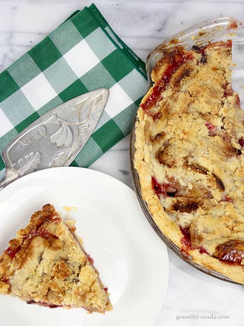 A cut piece of French Apple Cranberry Pie with a buttery crumb topping.