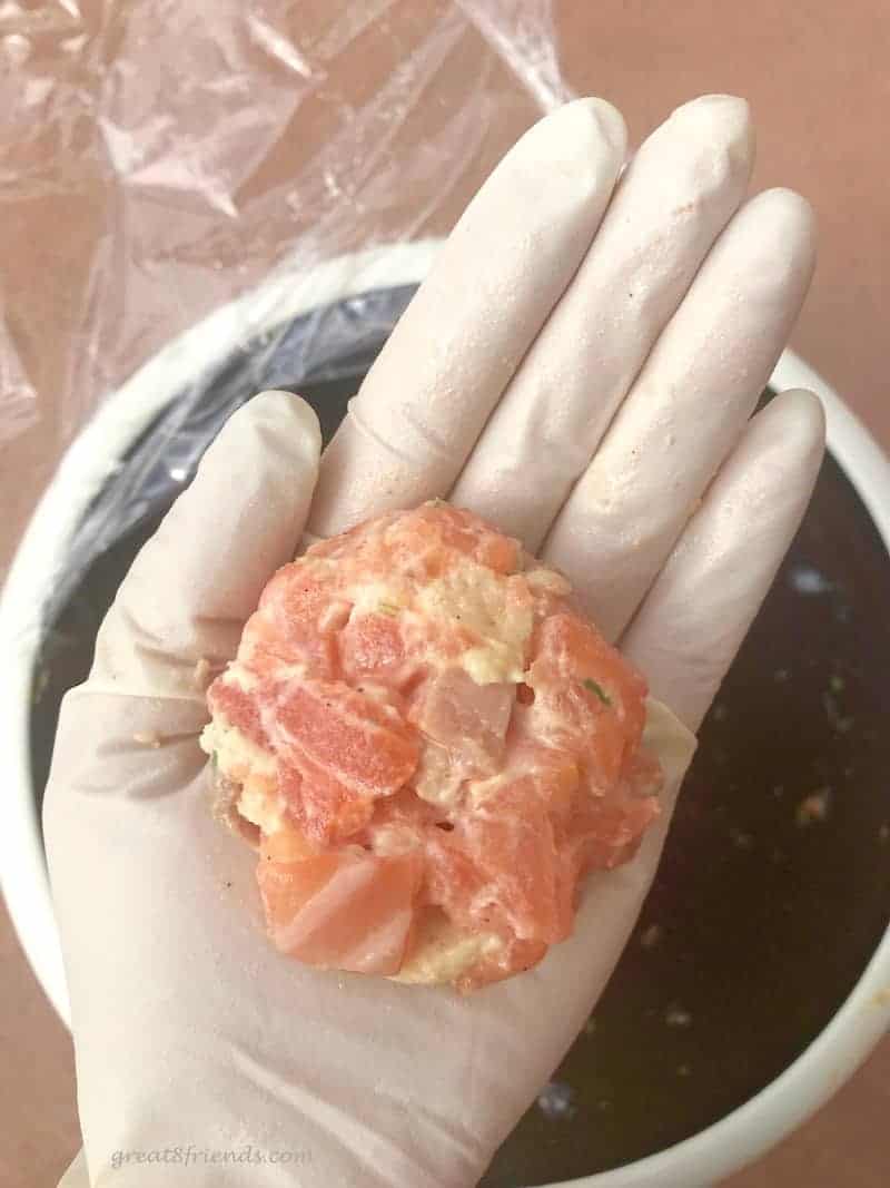 Salmon Slider raw in gloved hand.