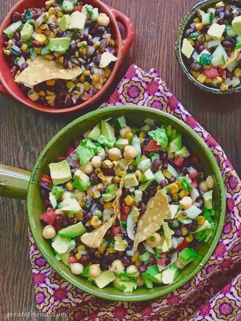 Overhead view of a green ceramic bowl with bean Cowboy Caviar in it.