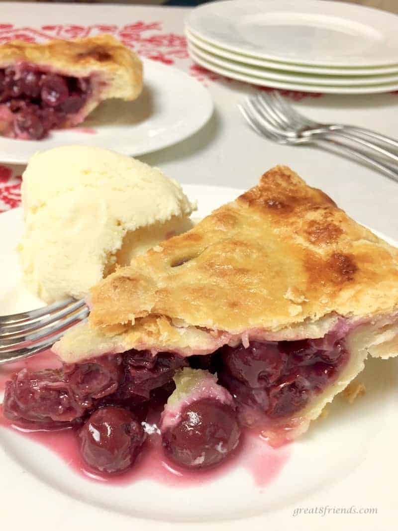 Slice of All-American Cherry Pie with a scoop of ice cream.