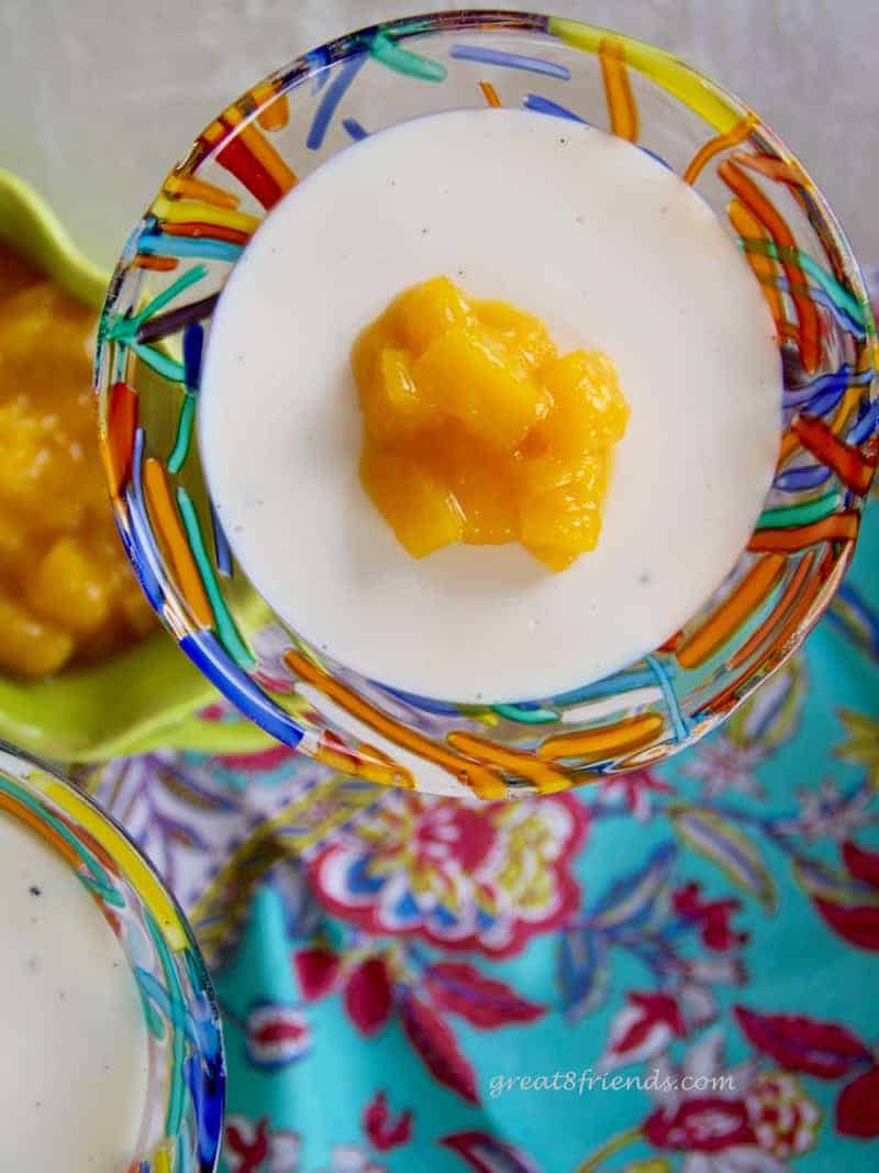 Overhead and unclose shot of vanilla Panna Cotta with a dab of mango compote on top.