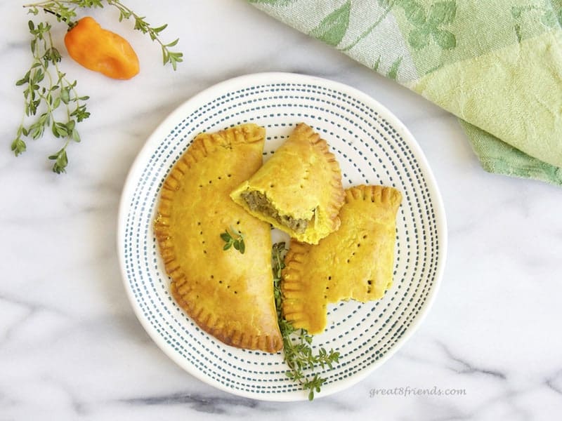 overhead shot of 2 Jamaican meat pies on serving plate.