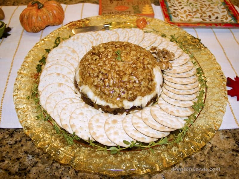 Fig Walnut Goat Cheese Terrine on a round yellow glass platter surrounded by crackers.