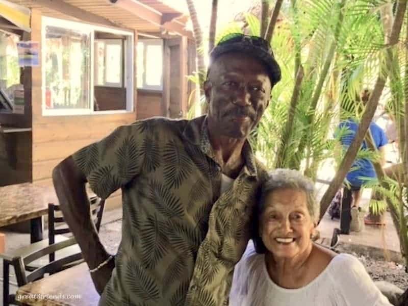 A woman and man posing for the camera at a restaurant in Jamaica.