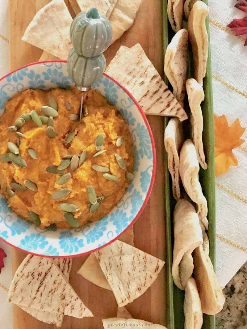 White bean pumpkin hummus served with pita bread pieces.