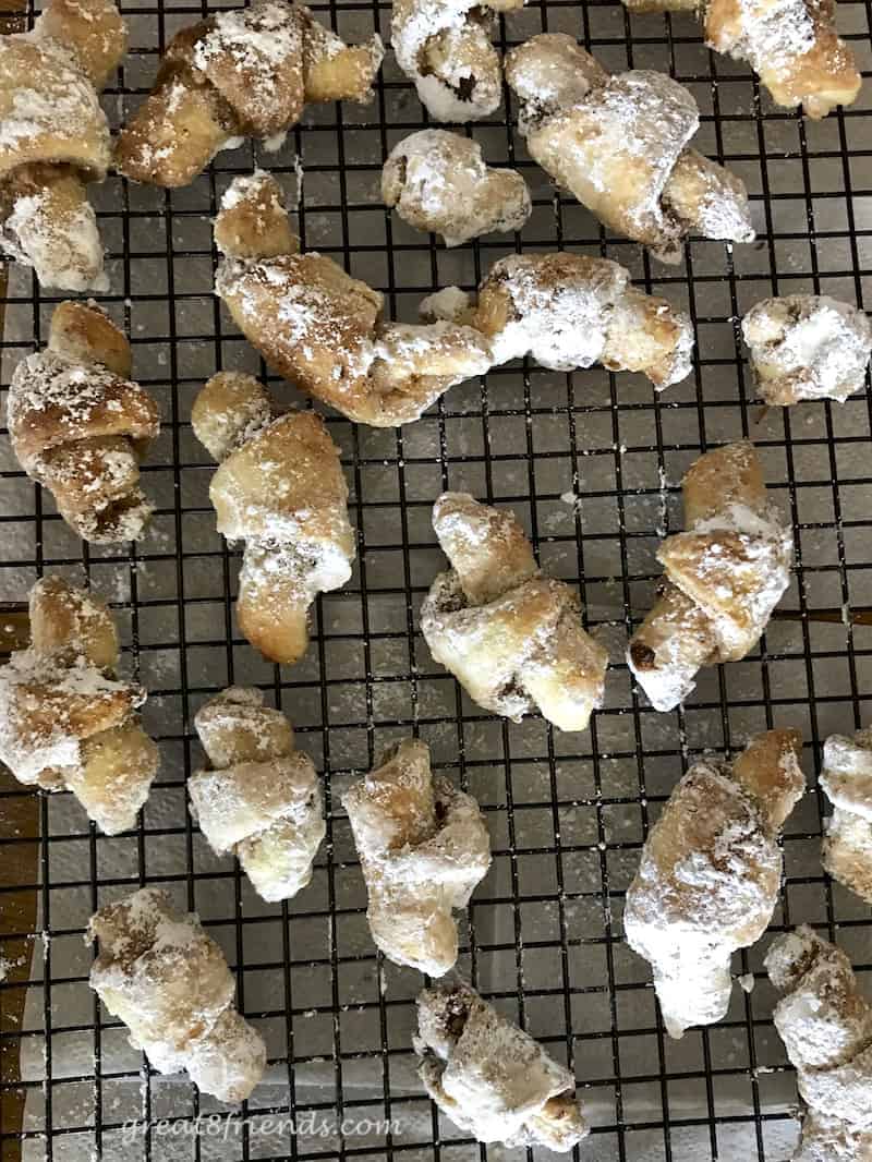 Pecan Walnut Crescent Cookies on a wire rack dusted with powdered sugar.