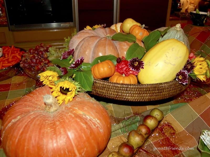 A centerpiece of pumpkins, gourds and flowers.