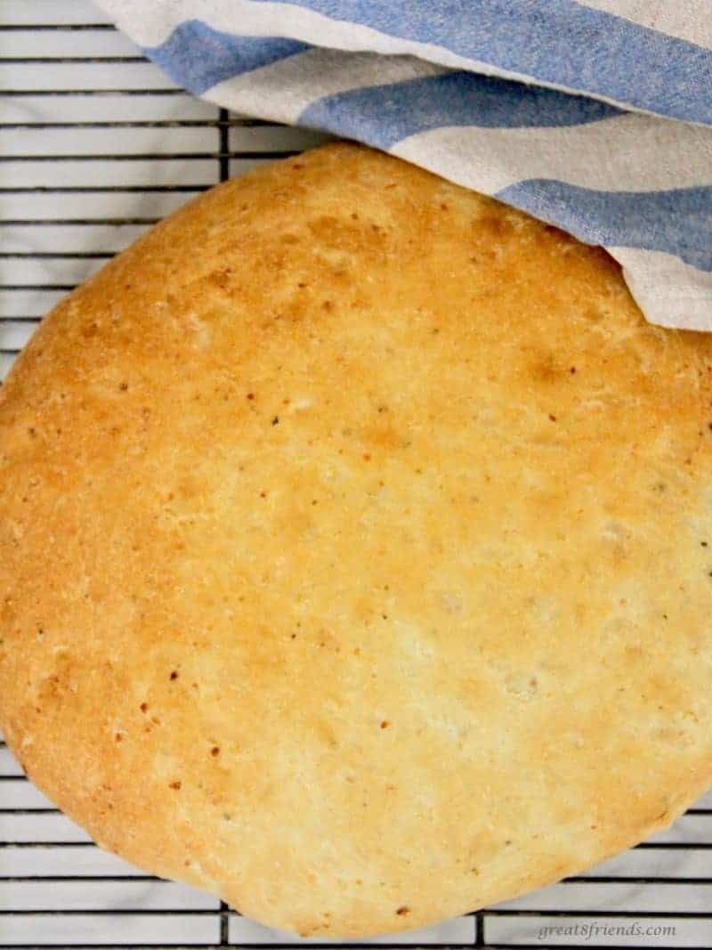 A whole Baked Onion Thyme Focaccia Bread right out of the oven cooking on a cooling rack.