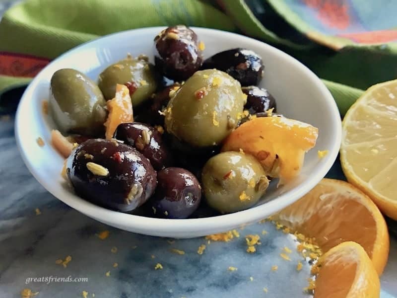 A small white bowl of citrus marinated olives.
