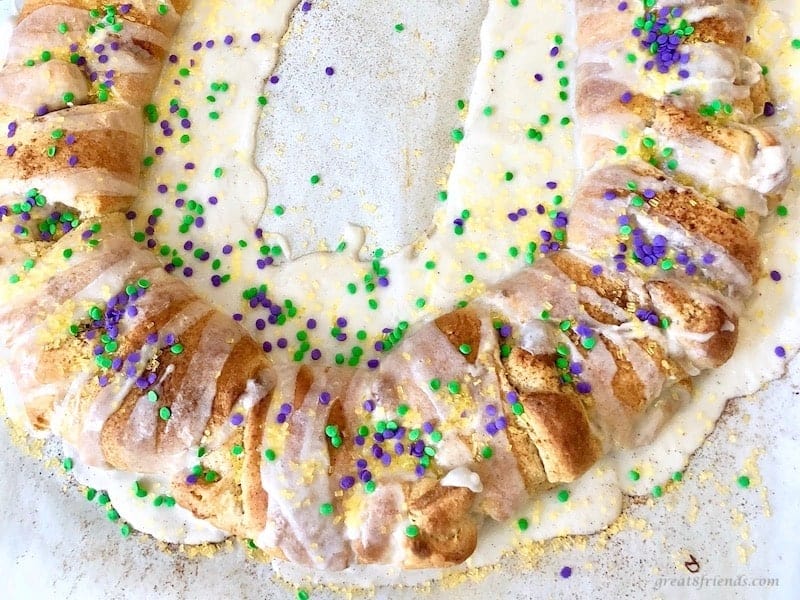 King cake decorated with purple, green, and gold sugars.