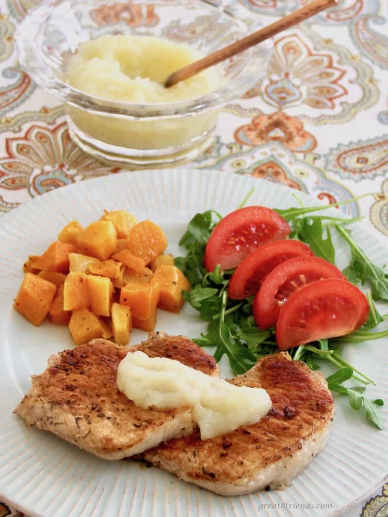 Pork and applesauce served with sliced tomatoes and cubed roasted squash.