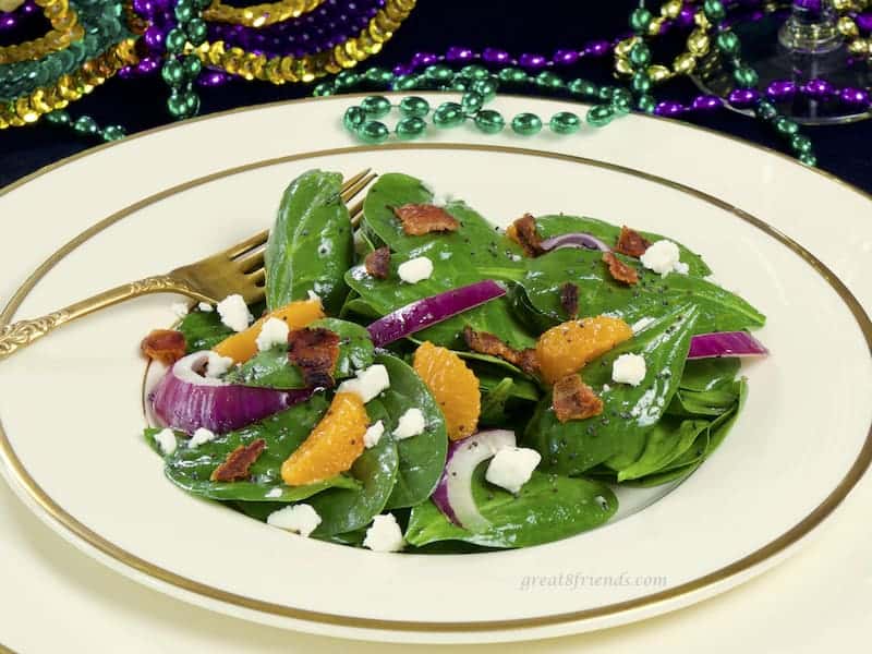 Spinach salad on ivory china with gold rim.