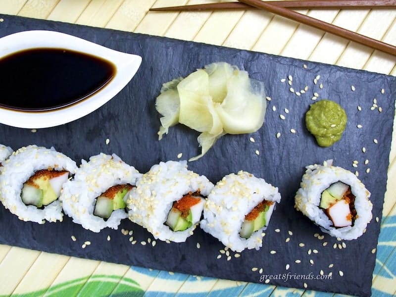 Overhead California Roll on slate with wasabi, ginger, and soy sauce