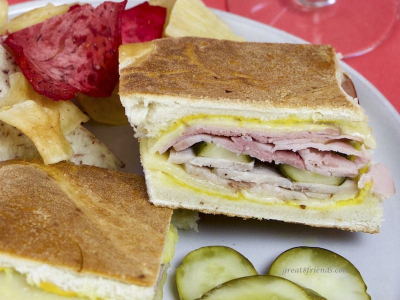 Cubano Sandwich on plate with pickles and Terra chips