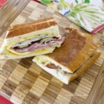 Cubano Sandwich cut in half on cutting board