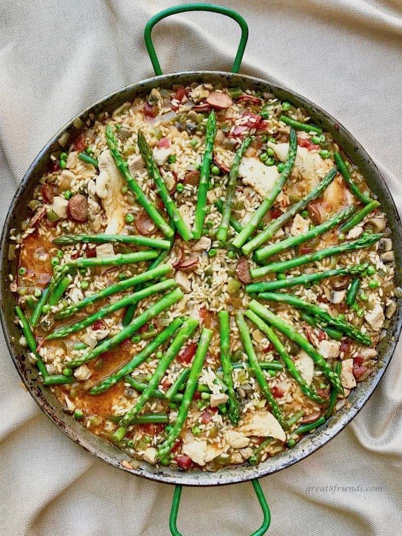 Overhead view of a pan of Paella with asparagus on the top.