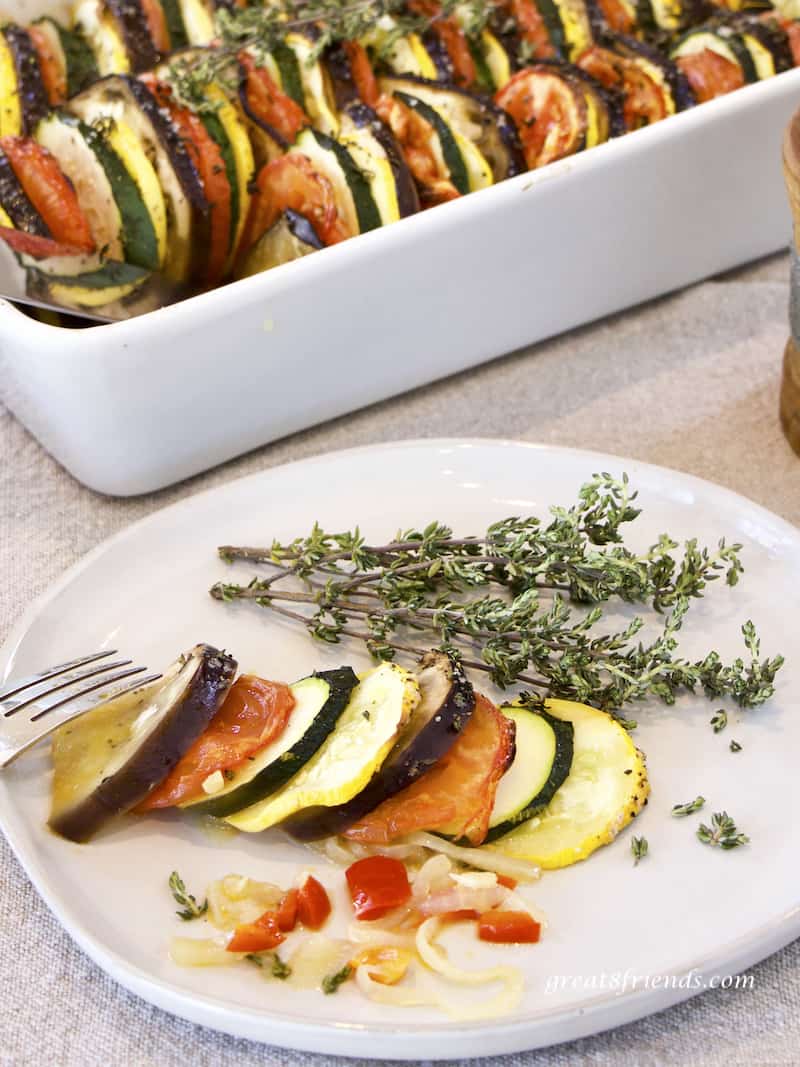 A serving of Provençal Vegetable Tian on white plate garnished with thyme