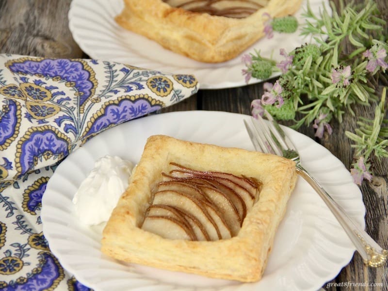 Individual pear tarts served with whipped cream