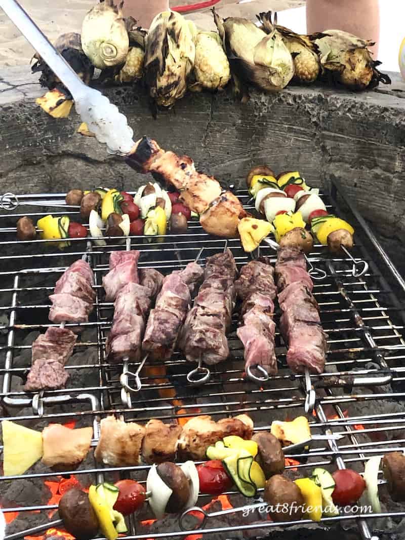 The skewered meats on the grill.