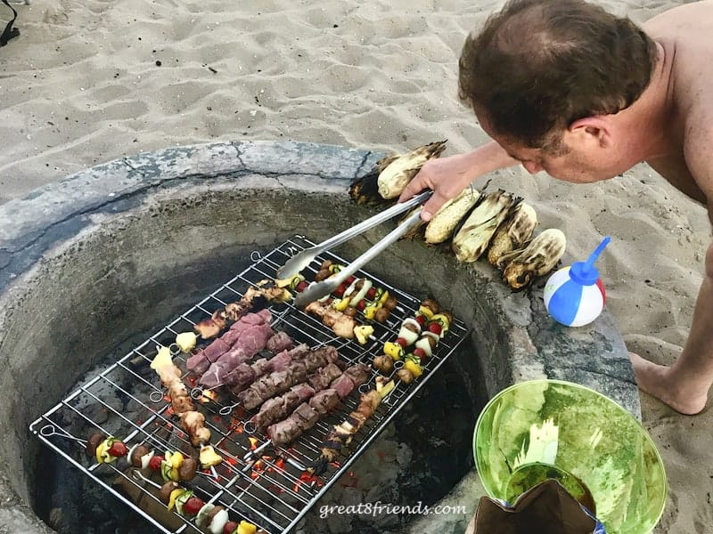 Vince grilling the skewers in the firepit.