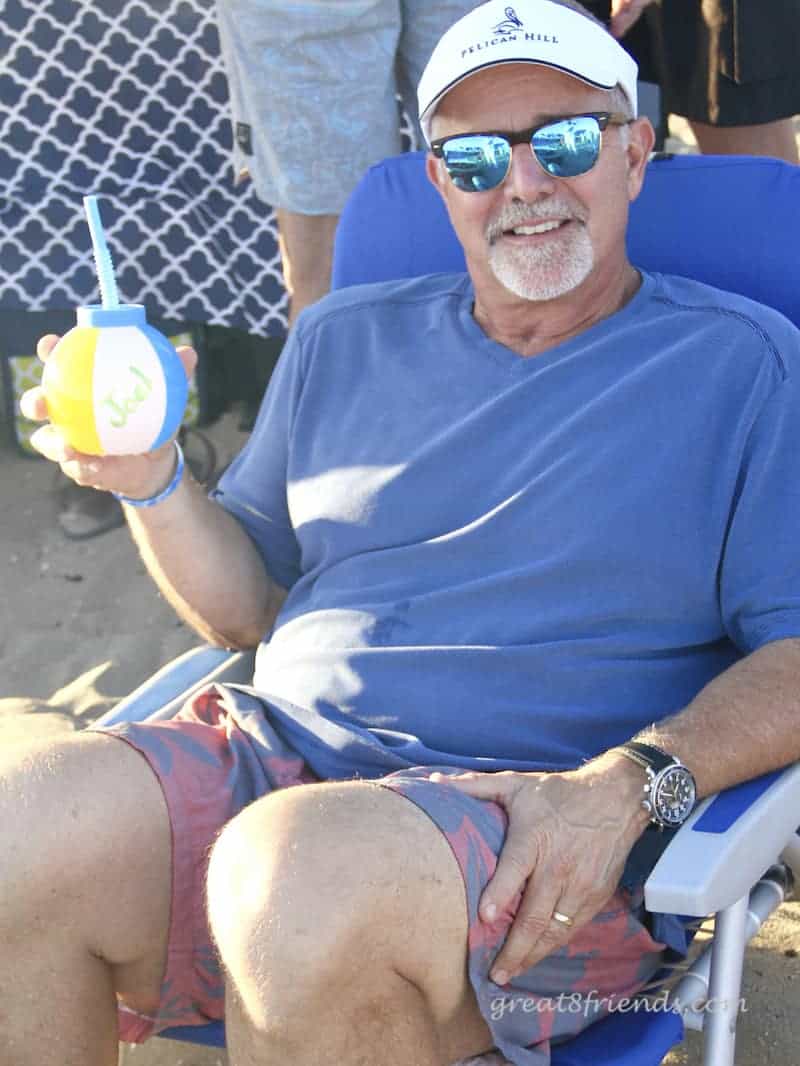 Joel sitting at the beach with his beach ball cup.