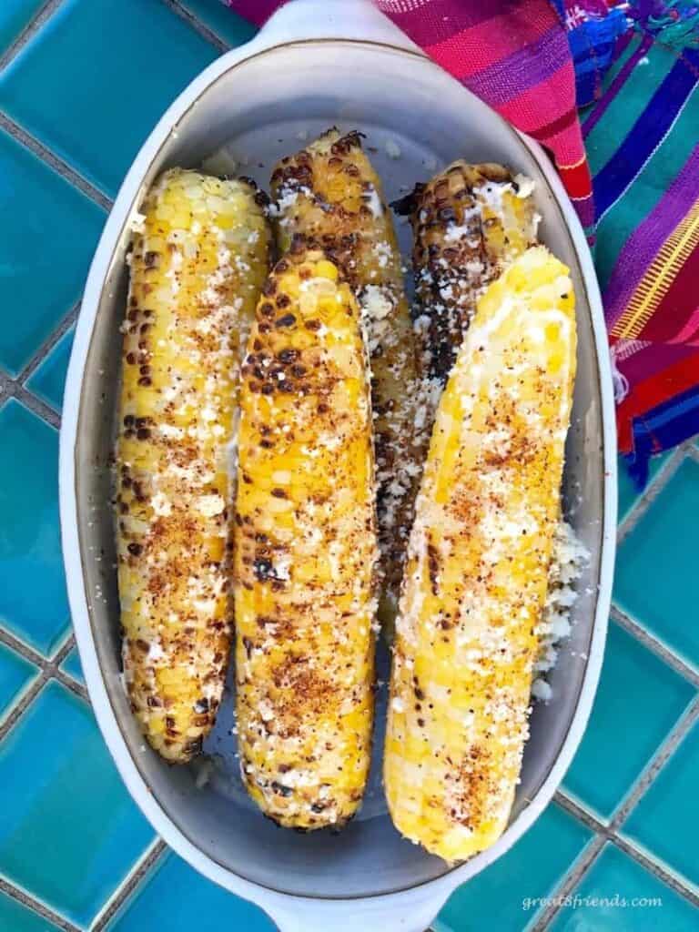 Overhead view of spicy grilled corn in an oblong bowl.