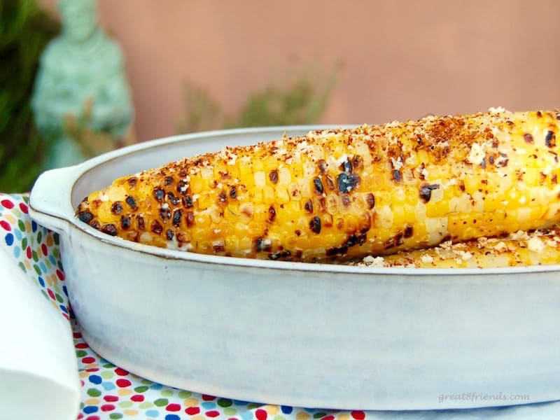 Cobs of spicy grilled corn in a bowl on the grill bar.