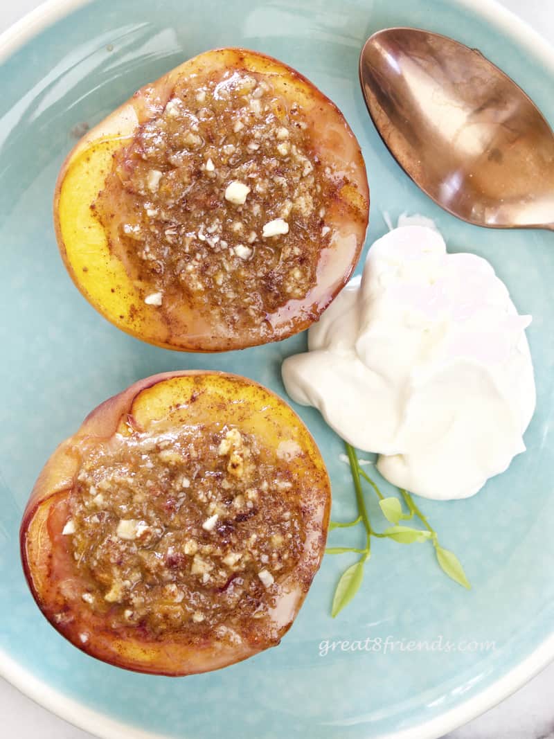 Two Baked Stuffed Peaches on a blue plate overhead shot.