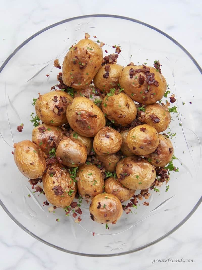 Poatatoes with an olive tapenade called dirty potatoes in a glass bowl.