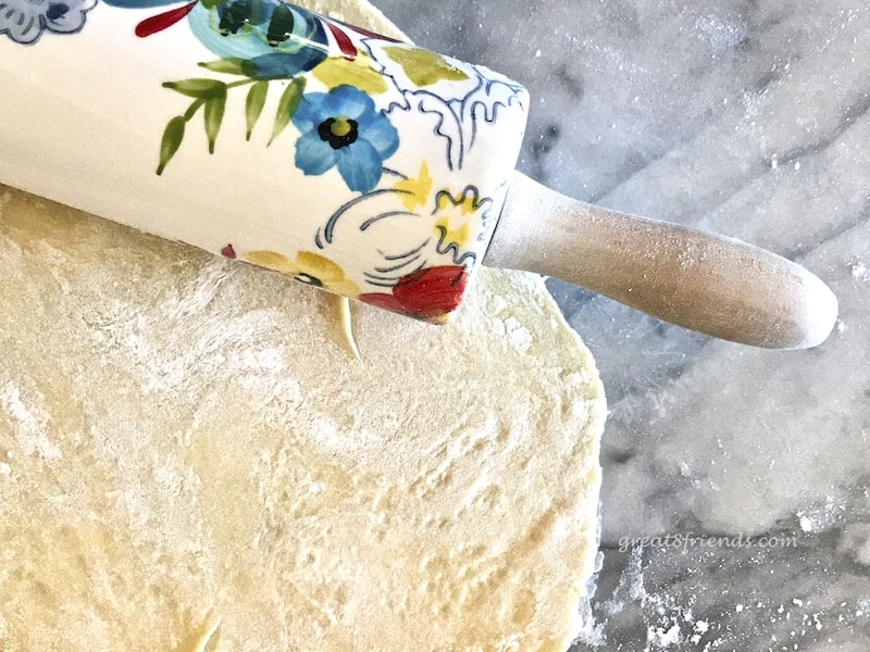 Ceramic Rolling pin with flowers on it rolling dough.