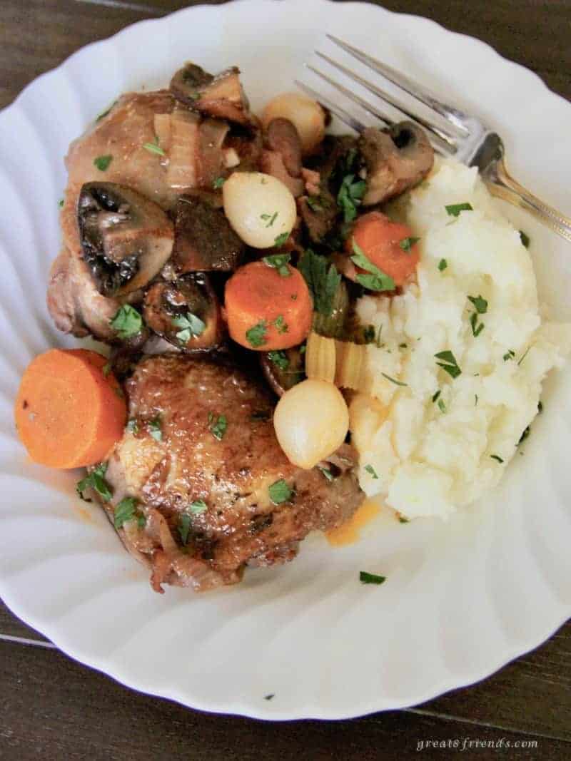 Overhead shot of plate of Coq au Vin with mashed potatoes.