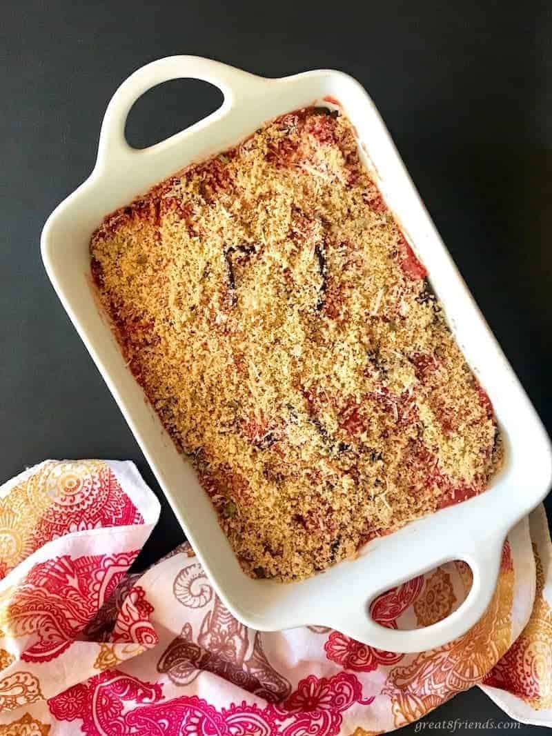 White baking dish filled with eggplant parmesan.