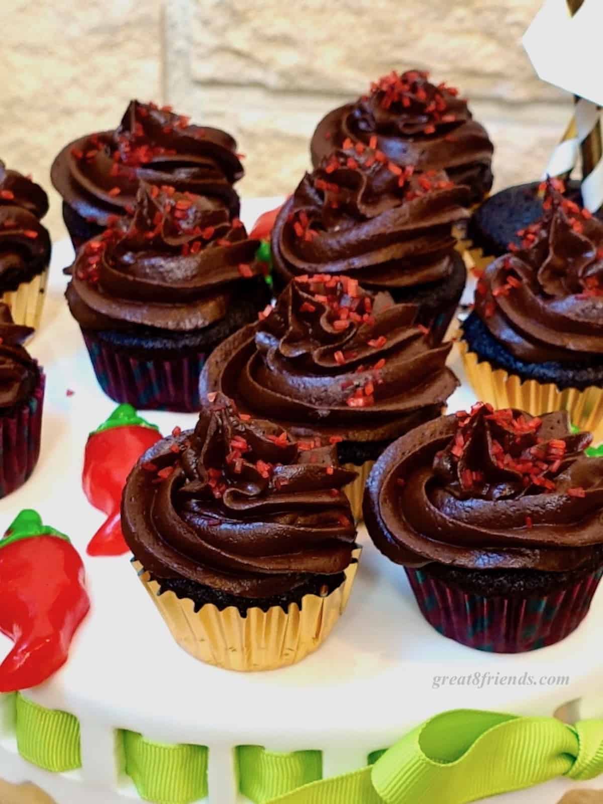 Chocolate Jalapeno Cupcakes on white platter with gummy candy peppers.