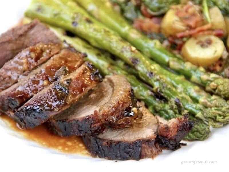 Marinated and butterflied leg of lamb sliced and served with sauce and grilled asparagus and bacon vinaigrette potato salad.