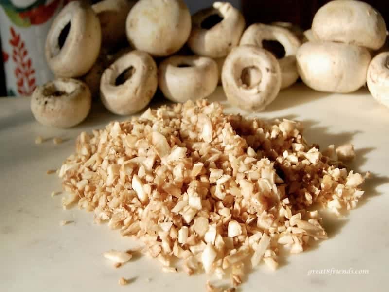 The stems of the mushrooms are chopped here to be included with the parmesan and prosciutto stuffing mix.