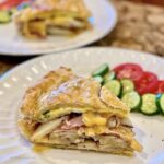 Brunch Torte cut and served with a cucumber and tomato salad.