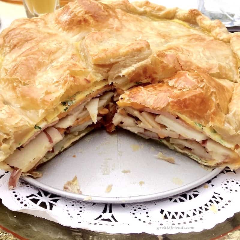 Baked and cut brunch torte showing the insides of potatoes, eggs and onions.