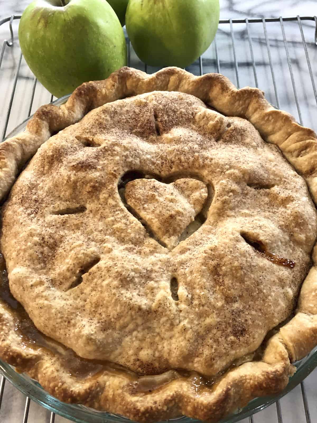 Baked apple pie with a heart cut in the top crust.