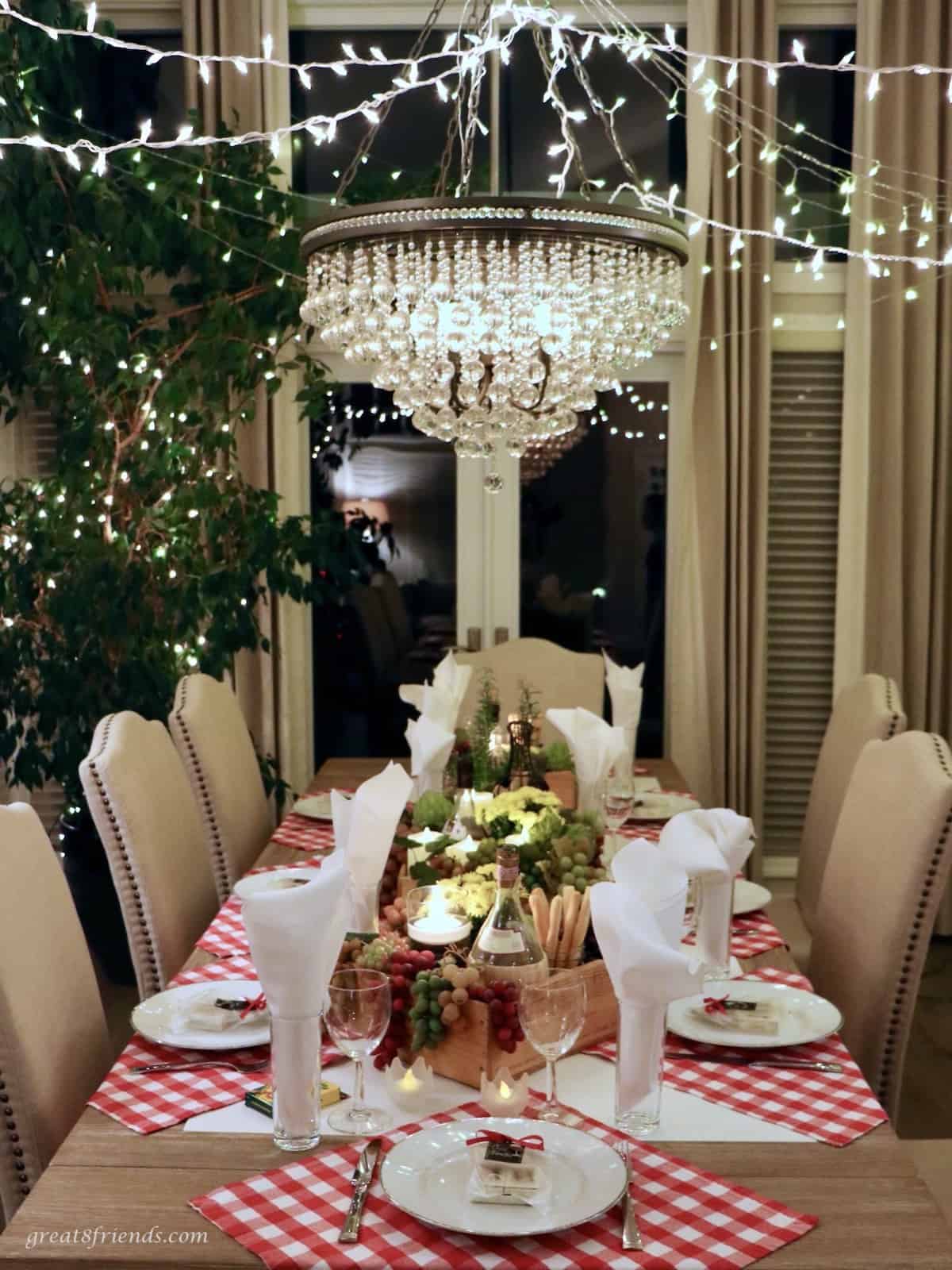 Table set for an Italian dinner with a chandelier over the table.